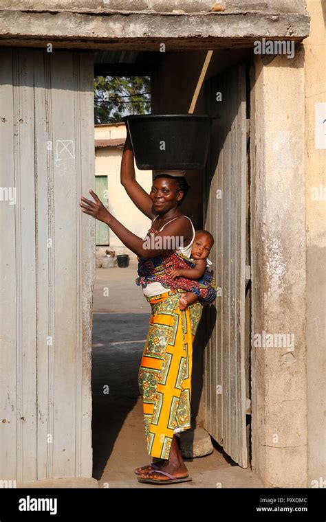 jeune femme africaine portant son bébé sur son dos corvée d eau photo