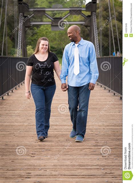 Smiling Interracial Couple Walking Holding Hands Stock
