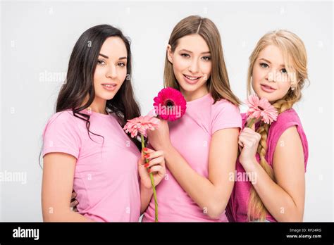 Beautiful Girls Standing With Flowers And Smiling Isolated On Grey