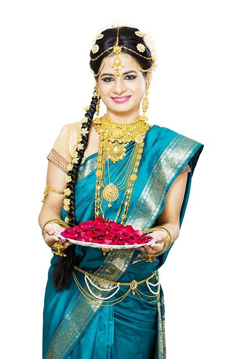 traditional south indian woman in gold jewelry holding plate of roses