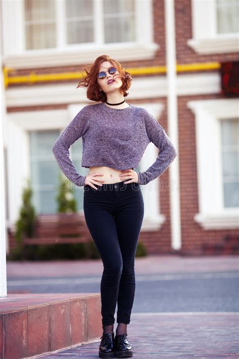 fashion hipster woman posing outdoor wearing gray jeans and gray
