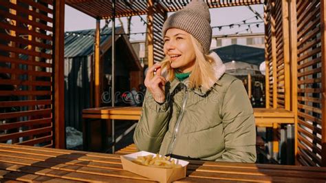Woman Eating Tasty French Fries In Outdoor Cafe Sunny Winter Day Stock