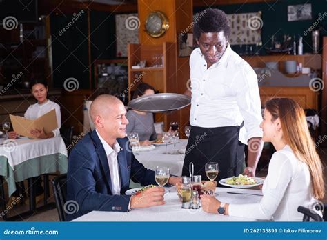 African American Waiter Bringing Ordered Dishes To Couple Stock Image