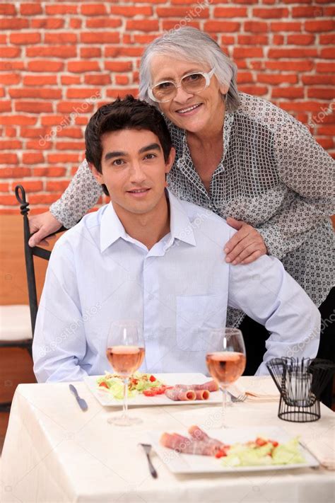 ein junger mann und eine alte frau posieren im restaurant