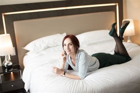 Elegant Stylish Businesswoman Wearing High Heeled Shoes Lying On Bed In