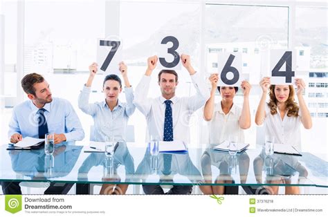 Group Of Panel Judges Holding Score Signs Royalty Free
