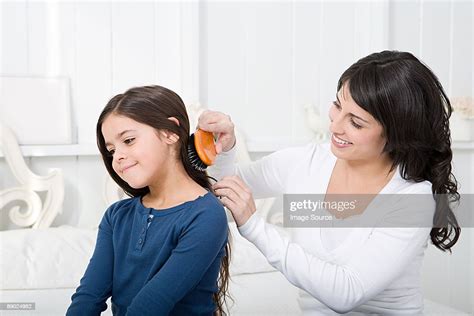 mother combing daughters hair photo getty images