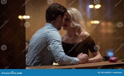 Blond Woman Sitting In Restaurant And Flirting With Handsome Man