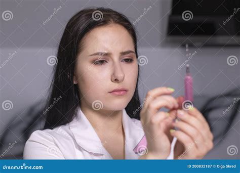 Attractive Brunette Nurse In White And Pink Medical Gown With A Syringe