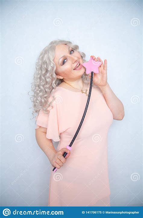 kinky pretty woman with pink star riding crop cute blonde woman holds bdsm whip on white solid