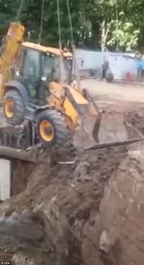 construction worker jumps as crane falls in pit in russia daily mail