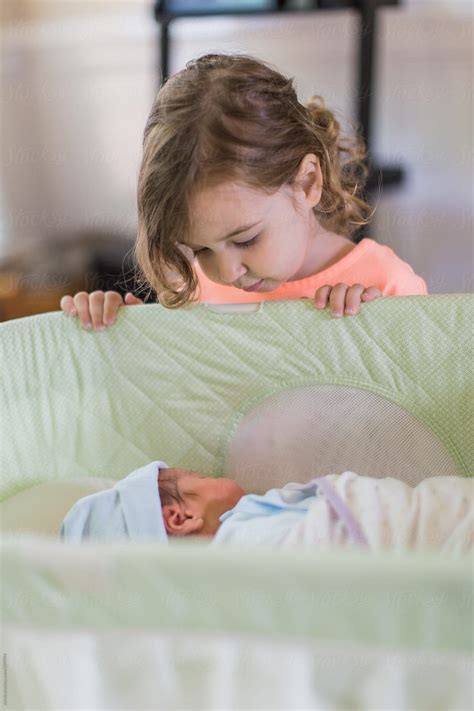 big sister looking at her newborn brother by jakob lagerstedt