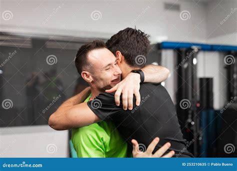 close up of a male trainee and trainer giving each other a hug at the