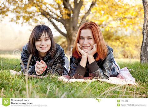 two beautiful girlfriends at the autumn park stock