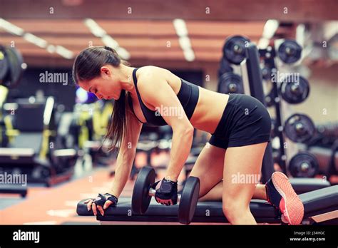 Mujer Joven Flexionando Los Músculos Con Pesa En El Gimnasio Fotografía