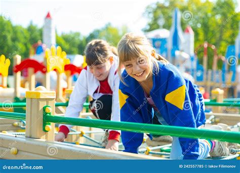 Portrait Of Happy Girlfriends Playing Outdoors On Playground Stock