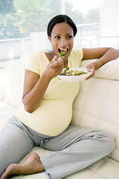 pregnant woman eating a salad photograph by ian hooton science photo
