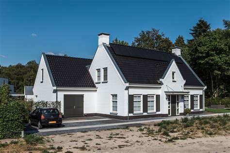 groothuisbouw emmeloord vrijstaande witte villa met donkere luiken en een middenrisaliet
