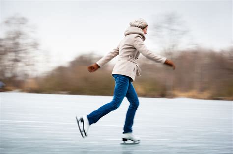 woman skating   ice rink   middle  winter  trees   background