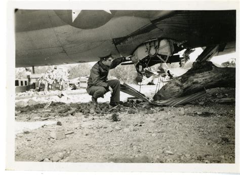 airman examining smashed ball turret     flying fortress thurleigh airfield