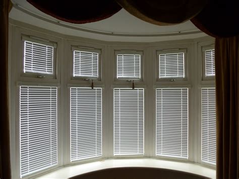 white wooden blinds bay window