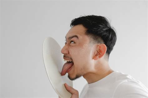 Funny Face Man Is Licking White Dish In Concept Of Very Delicious Meal