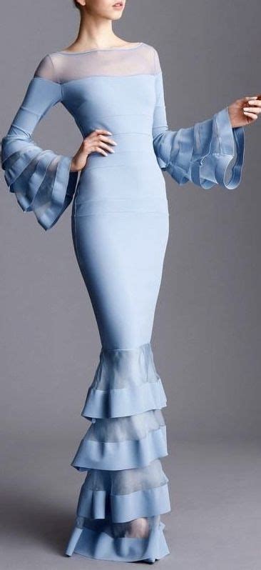 light blue fitted gown with sheer shoulders and neck line and ruffles on the large bell sleeves