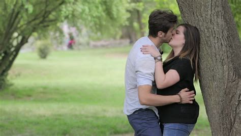 couple in love kissing near a tree park love sex