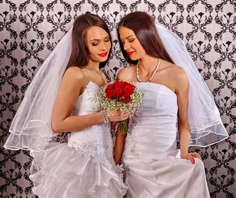 Ślubna lesbians dziewczyna w bridal sukni utrzymaniach kwitnie zdjęcie