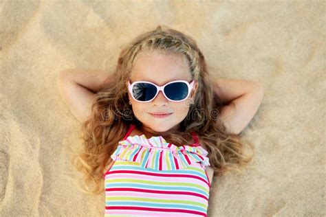 Top View Of Pretty Little Blonde Girl In Sunglasses Lying On Sandy