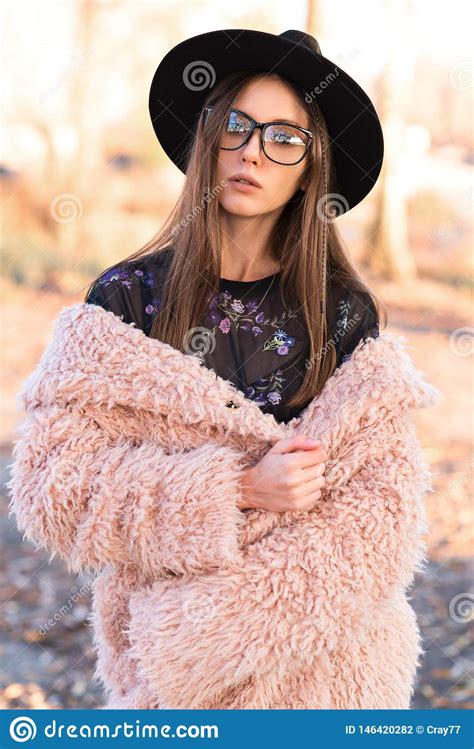 beautiful brunette in fashion glasses and a shaggy coat