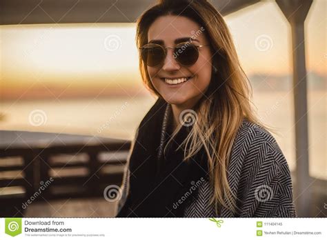 beautiful happy woman in sunglasses standing at the sea