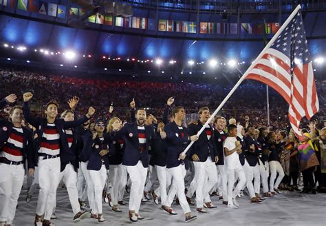 michael phelps carries the flag of the united states during the opening