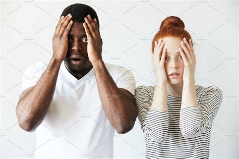 portrait of shocked interracial couple african man and redhead