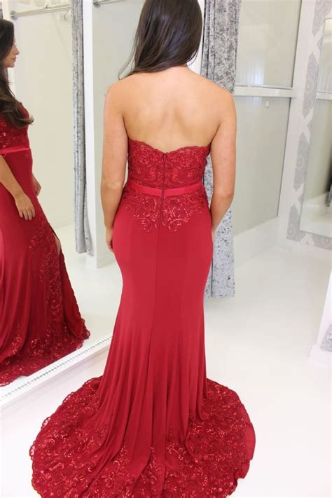 red strapless full length prom dress with leg split and lace train