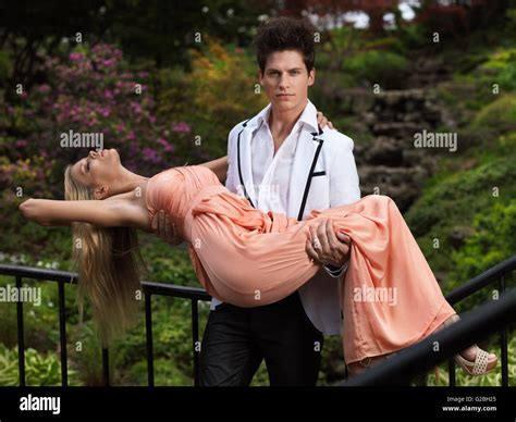 man carrying  fainting woman   arms   park ontario stock photo  alamy