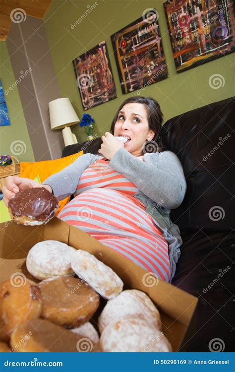 pregnant woman eating donuts stock photo image