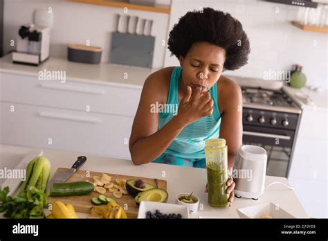 Mid Adult African American Woman Licking Finger While Drinking Healthy