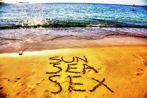 sun sea and sex written in the sand on the beach photograph by paul