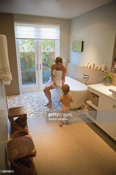 mom trying to coax her small son into the bath tub photo getty images