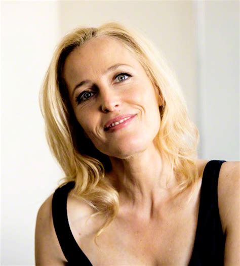 woman  blonde hair  blue eyes smiling   camera  wearing  black tank top