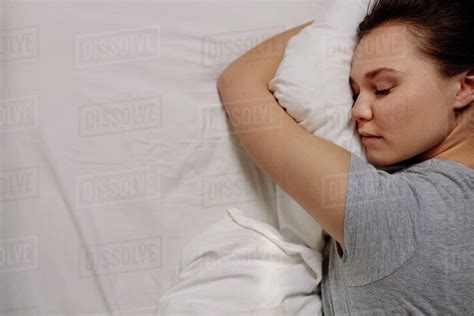 top view of a woman sleeping on bed holding a pillow close up of a