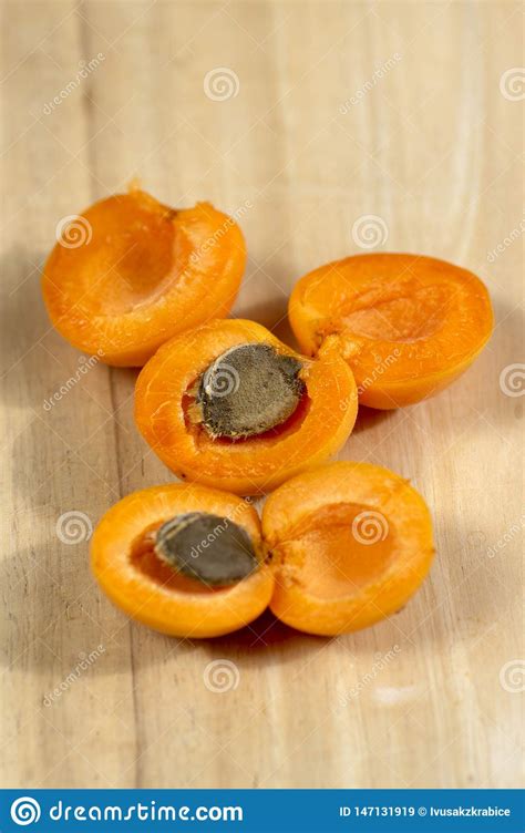 Fresh Ripened Apricots Cut In Halves With Stone On Wooden Table In