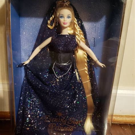 a barbie doll in a plastic case on a wooden floor with a blue dress and