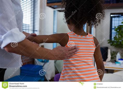 Physiotherapist Giving Back Massage To Girl Patient In
