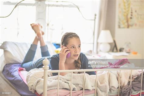 Teen Girl Laying On Bed Talking On Phone High Res Stock