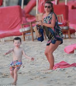 kai rooney splashes about in the water on barbados beach
