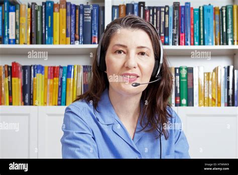 Experienced Woman With Headset And A Blue Shirt In A Library Talking