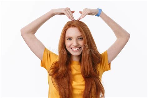 Pretty Romantic Young Redhead Woman Making A Heart Gesture With A Happy