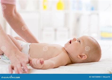 baby massage mother massaging   gymnastic   kid stock photo image  diaper